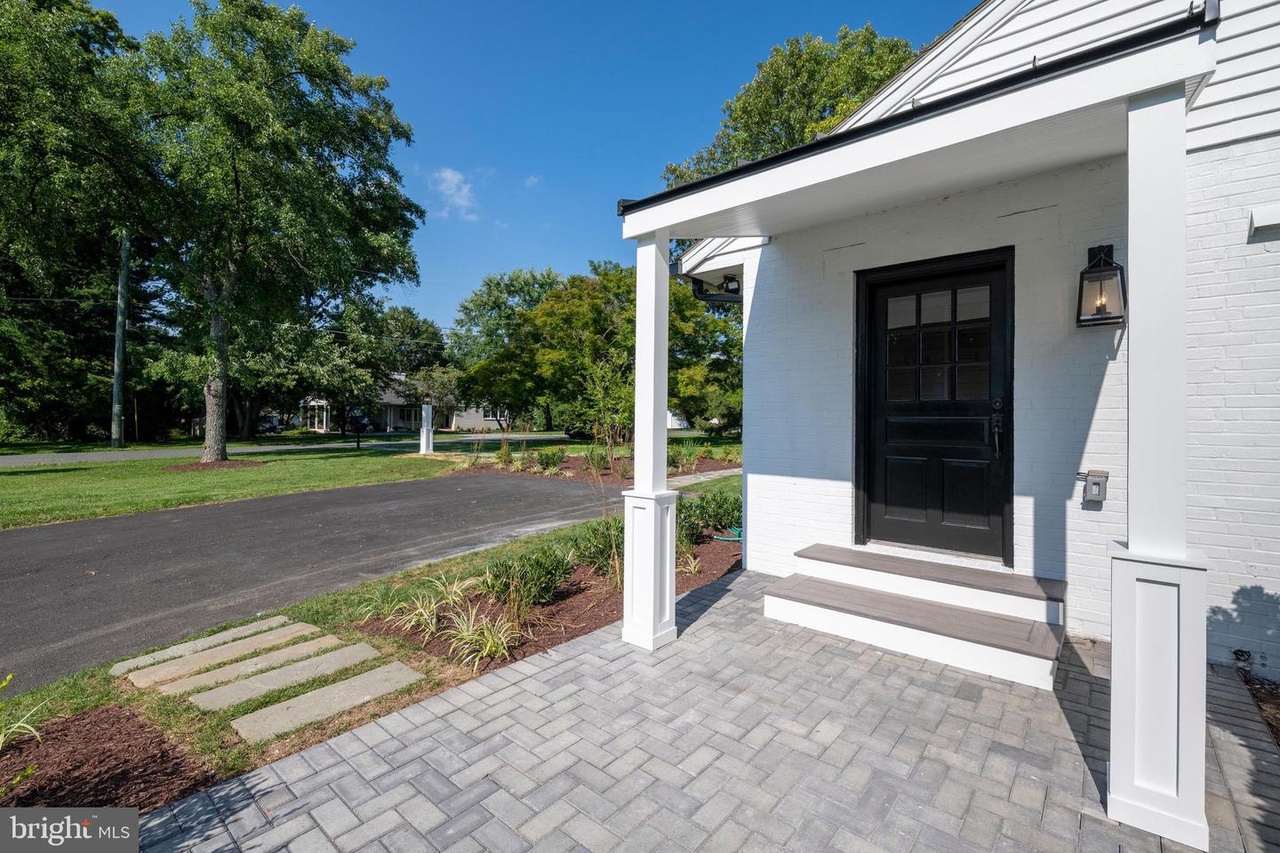 Chapel Ridge — covered side entrance with a black door and paver patio