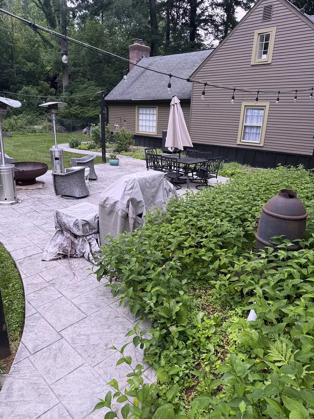 Stamped concrete patio with a fire pit and garden planting