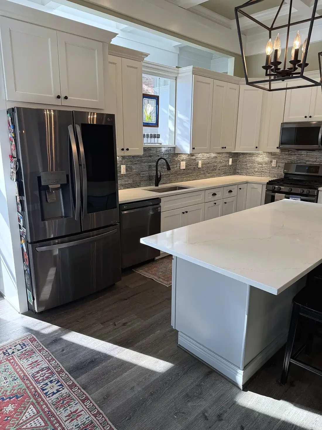White kitchen with a large island, range and panelled refrigerator